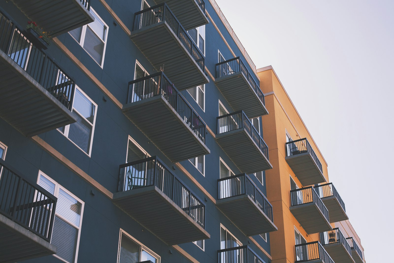 Apartment balconies on a teal and orange facade