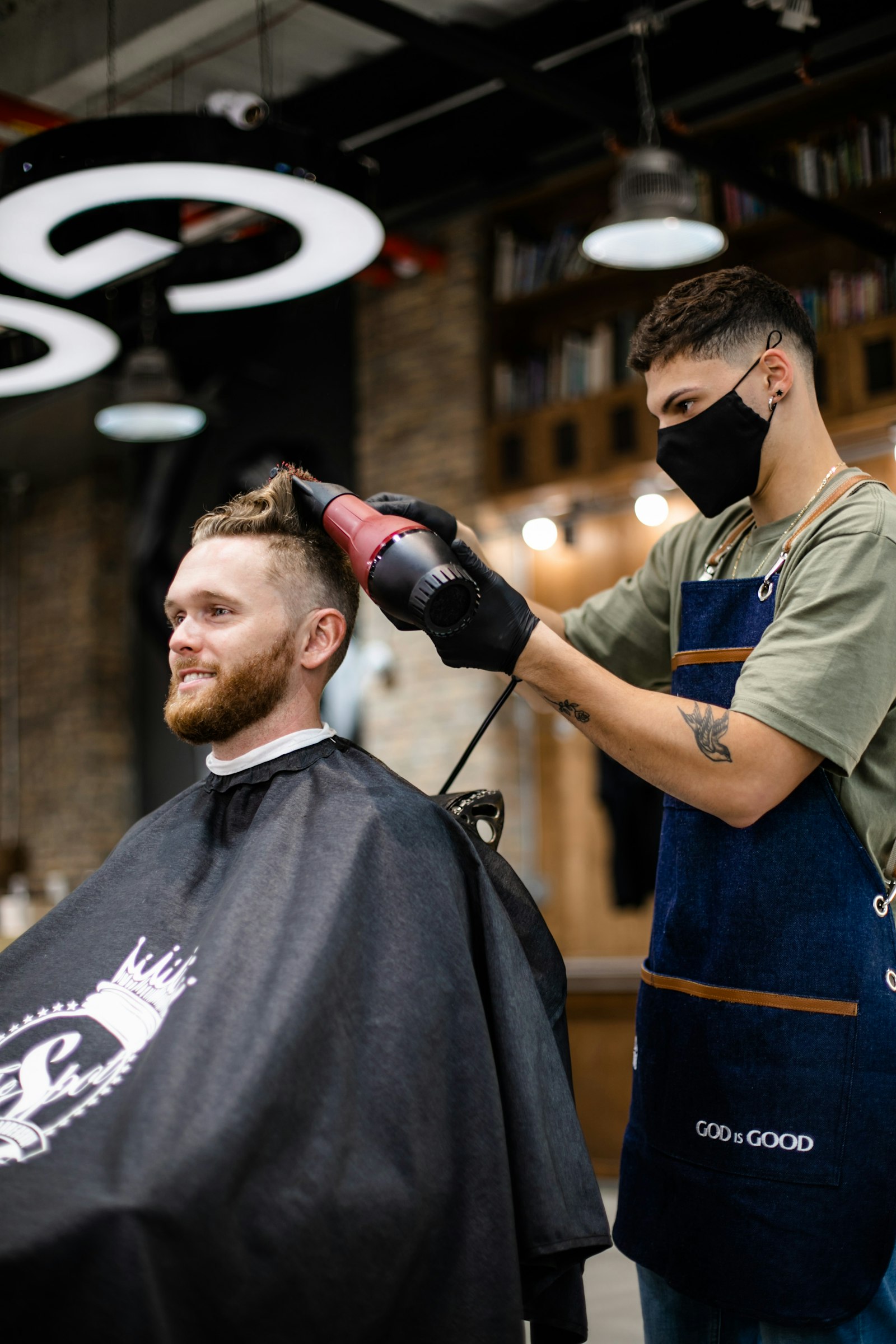 Barber blow-drying a bearded client's hair