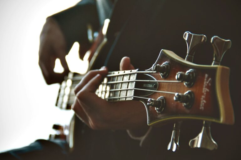 Hands playing a bass guitar