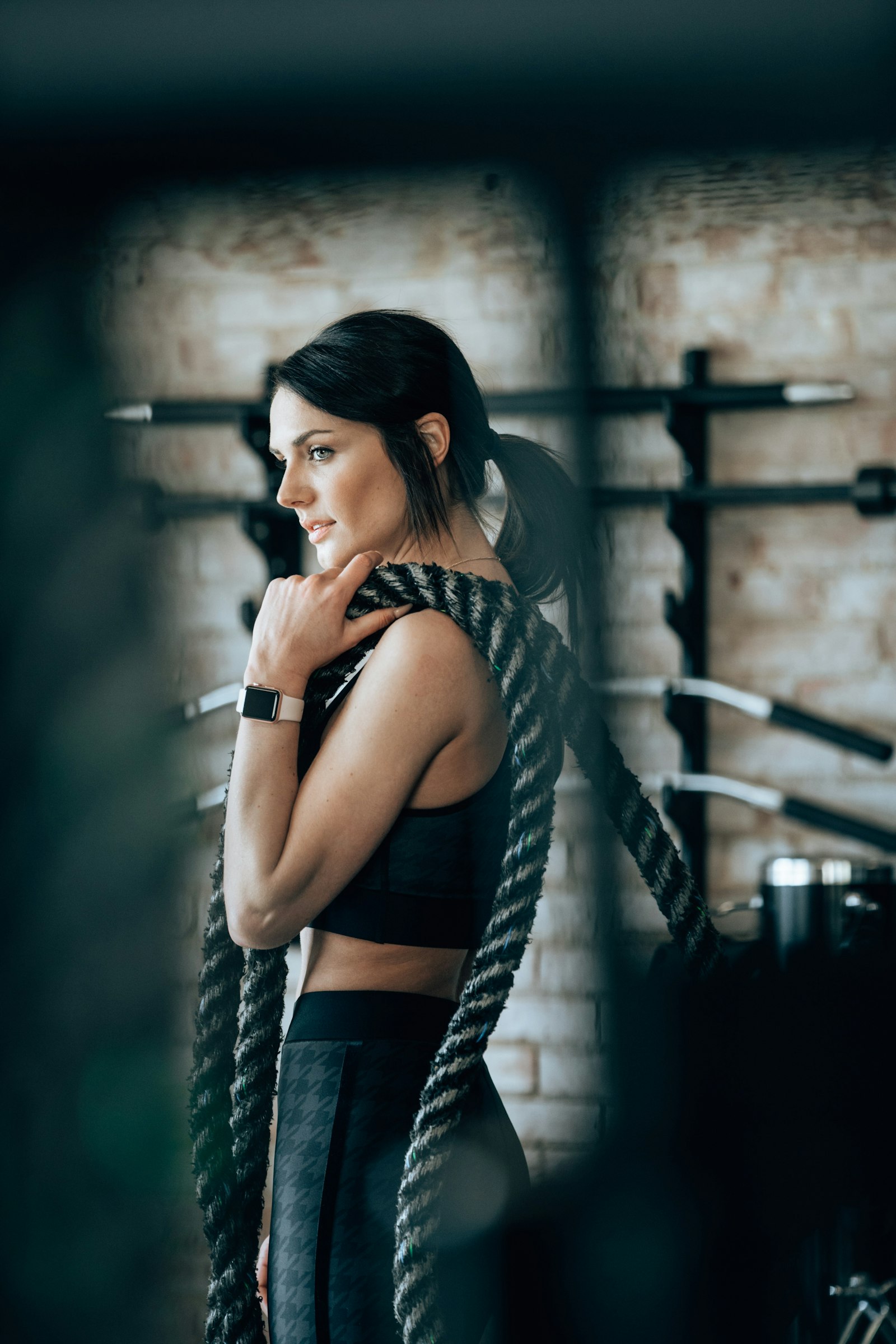 Woman with battle rope draped over her shoulders