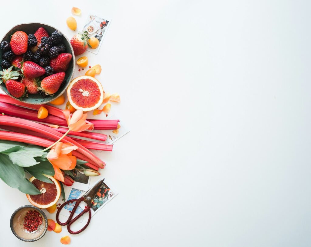 Berries, rhubarb and blood orange on white
