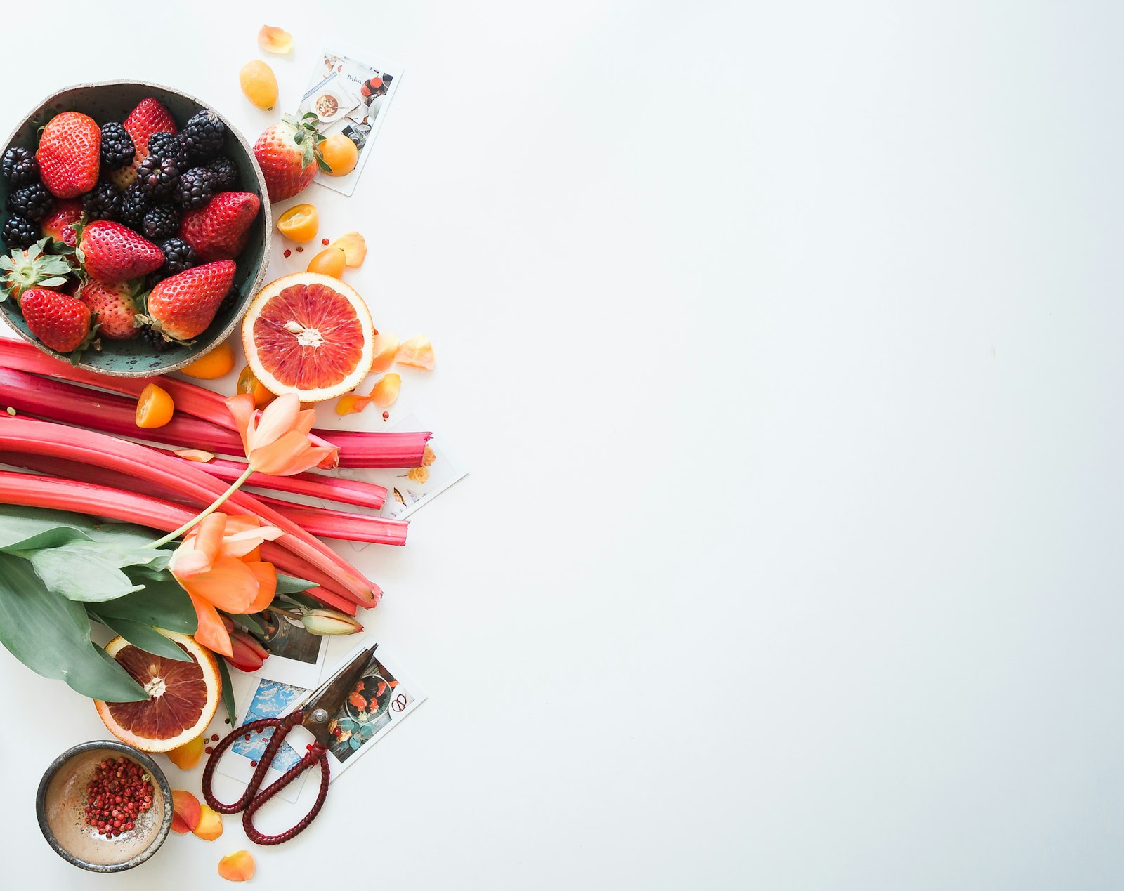 Berries, rhubarb and blood orange on white
