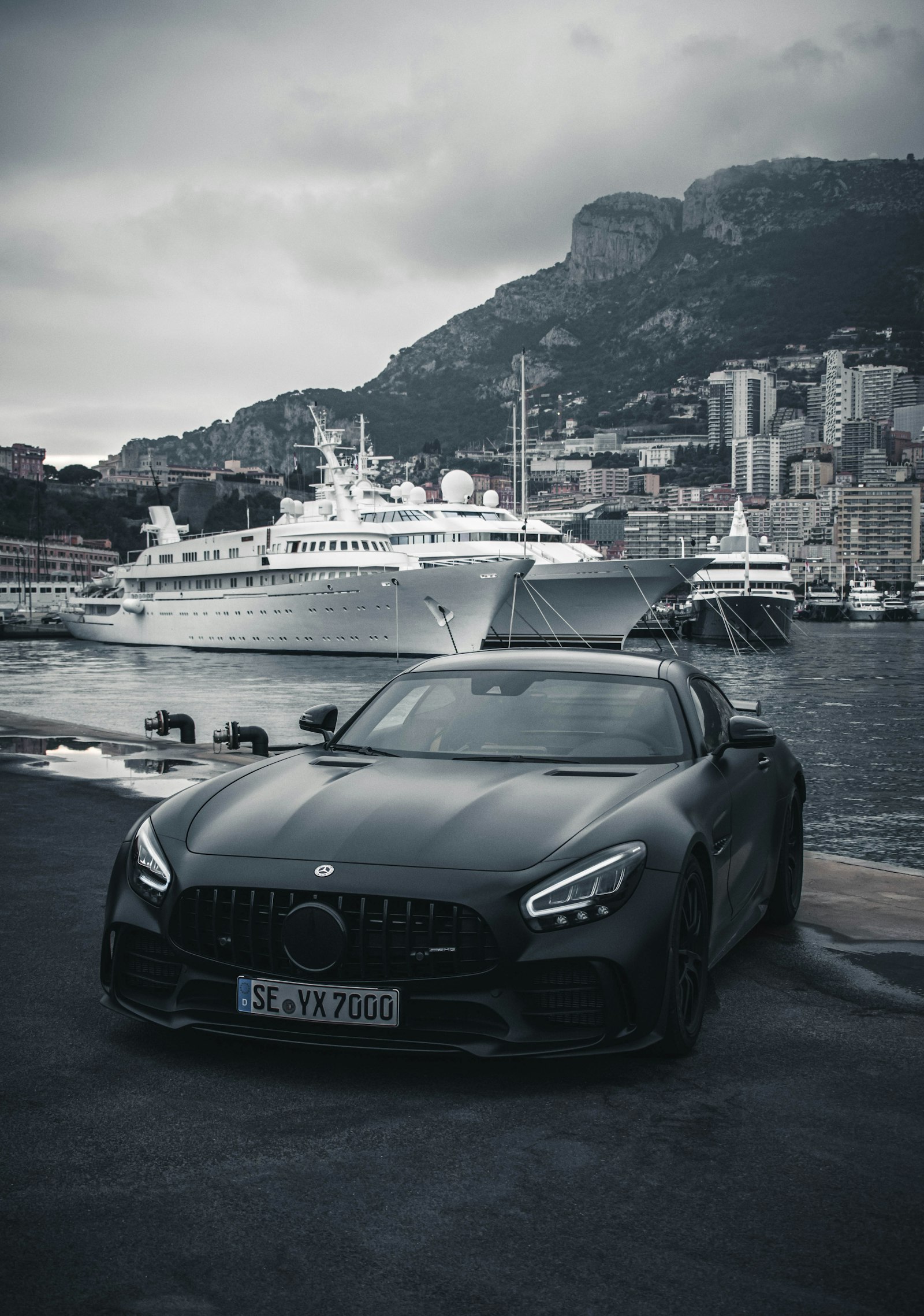 Matte black sports car at a yacht harbor