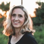 Smiling blonde woman outdoors at golden sunset