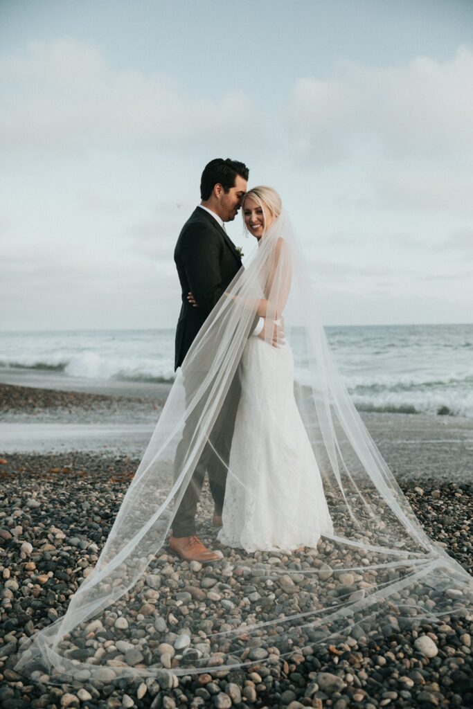 Bride and groom on a pebble beach