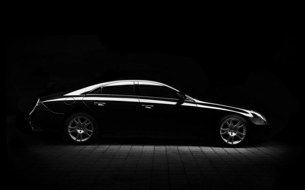 Car silhouette against black
