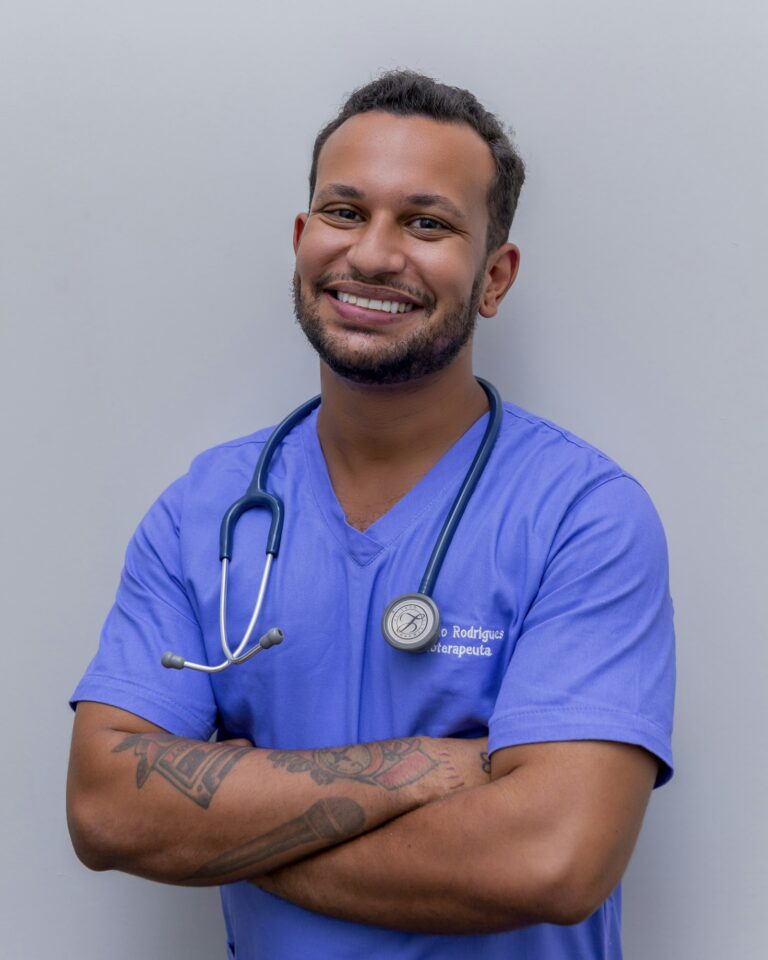 Smiling clinician in scrubs with a stethoscope
