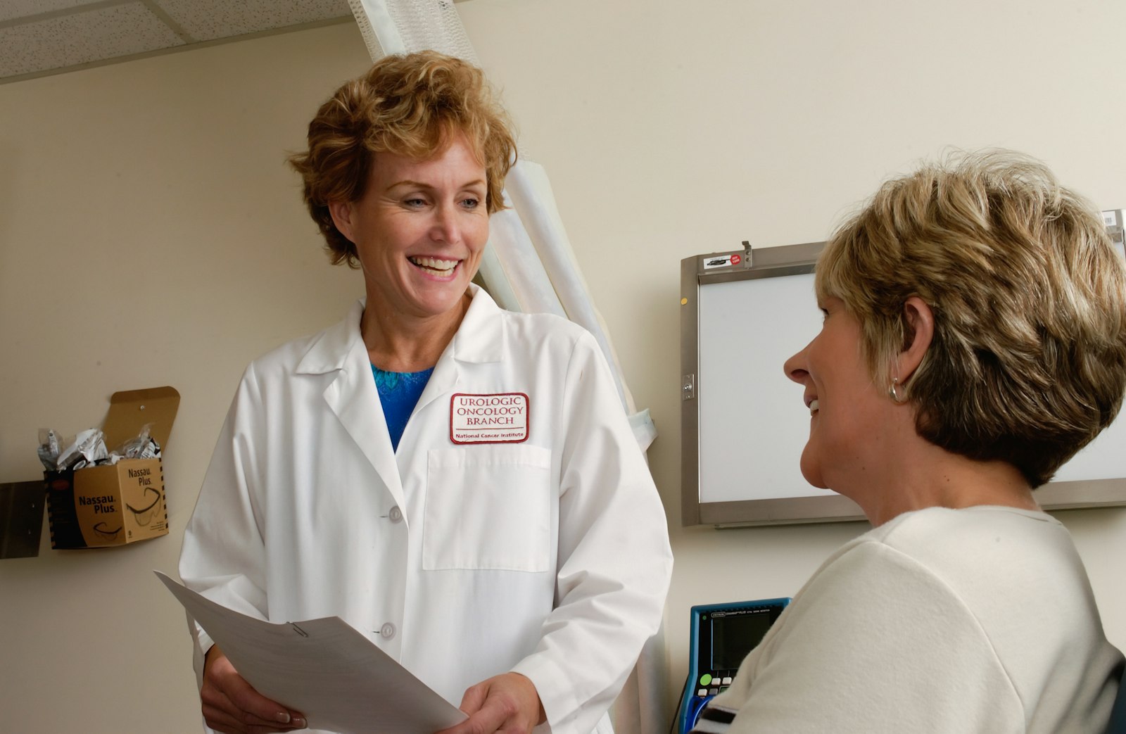 Smiling doctor in a white coat going over notes with a patient