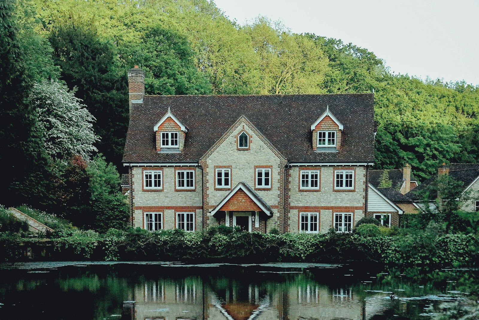Brick country house beside a wooded pond