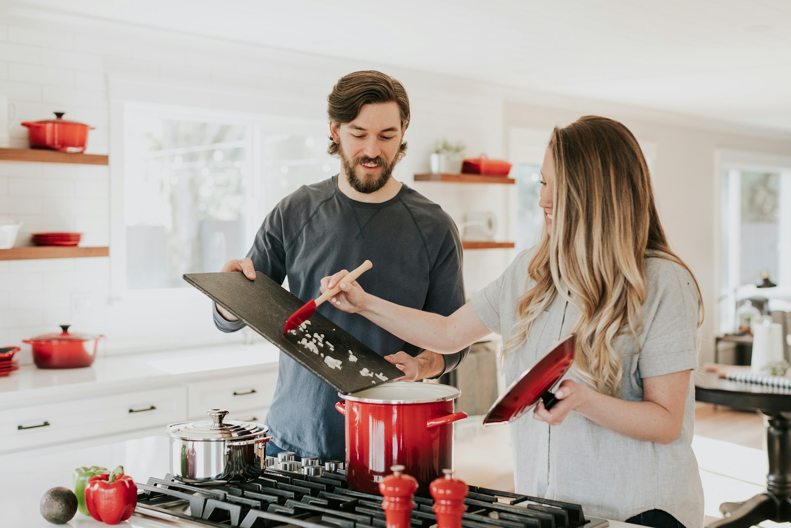 Couple cooking together in a white kitchen