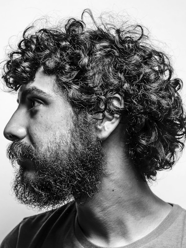 Profile of a curly-haired bearded man, monochrome
