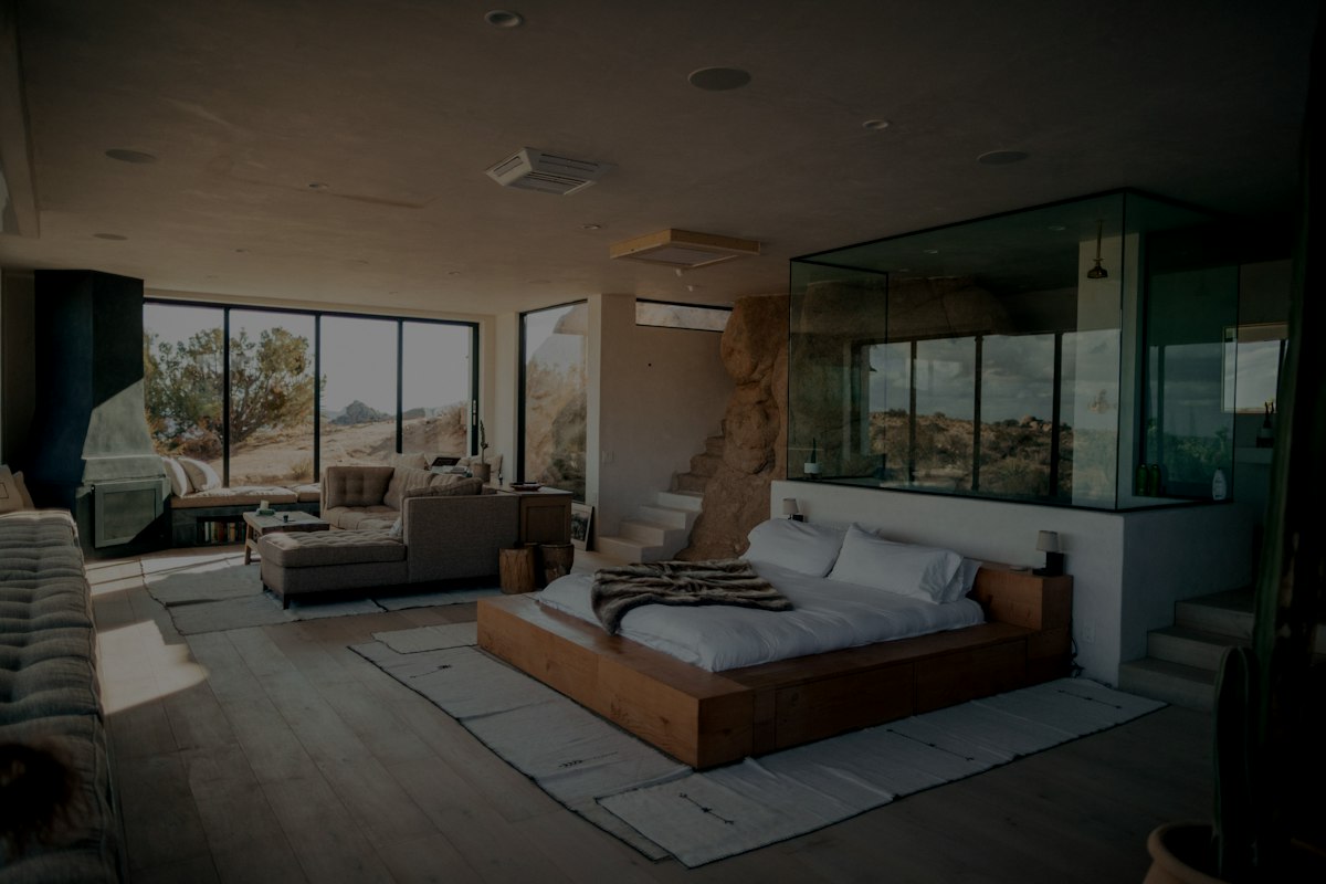 Open bedroom with glass shower and desert view