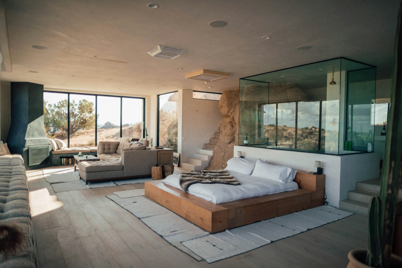 Open bedroom with glass shower and desert view
