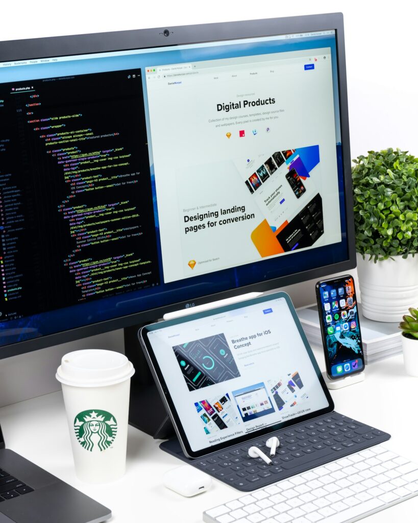 Monitor with code and design work on a desk