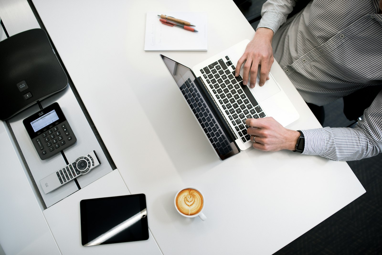 Overhead desk with hands typing on a laptop