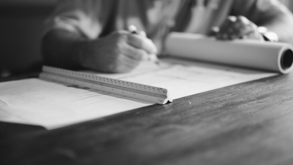 Hands drafting with a ruler and pencil