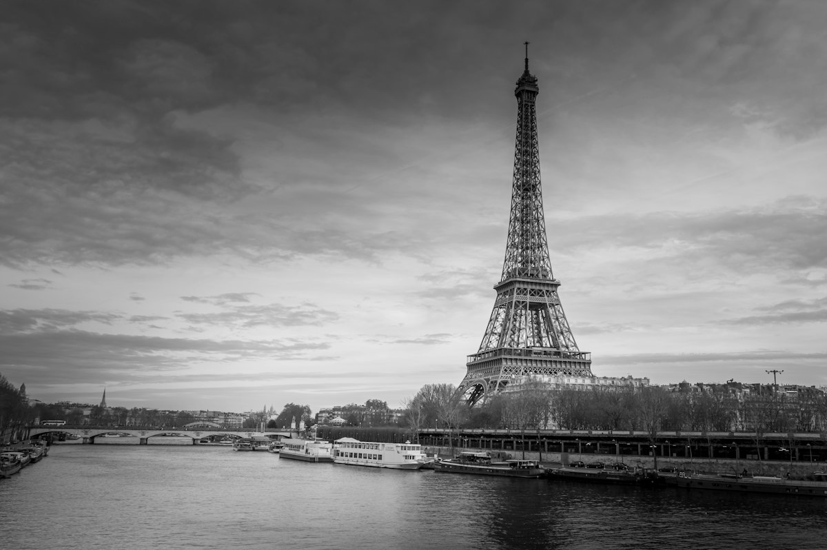 The Eiffel Tower above the Seine under a lilac dusk sky