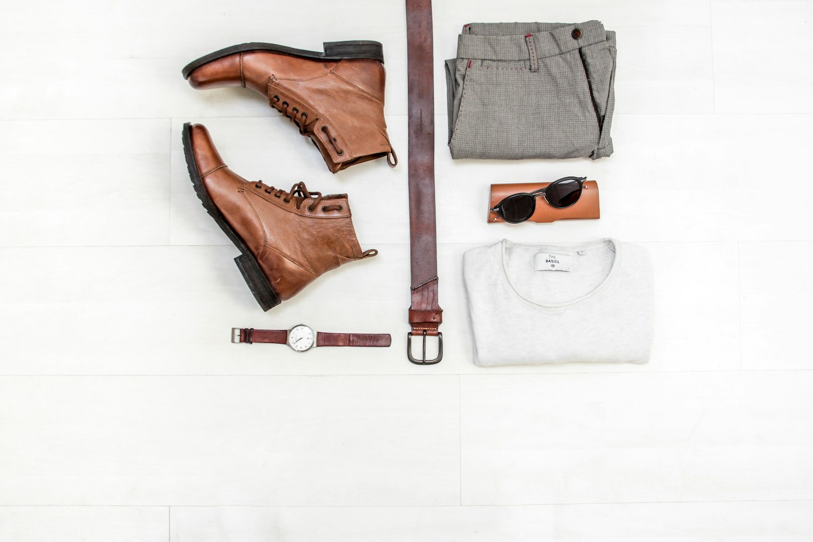 Flat-lay of boots, belt and a watch