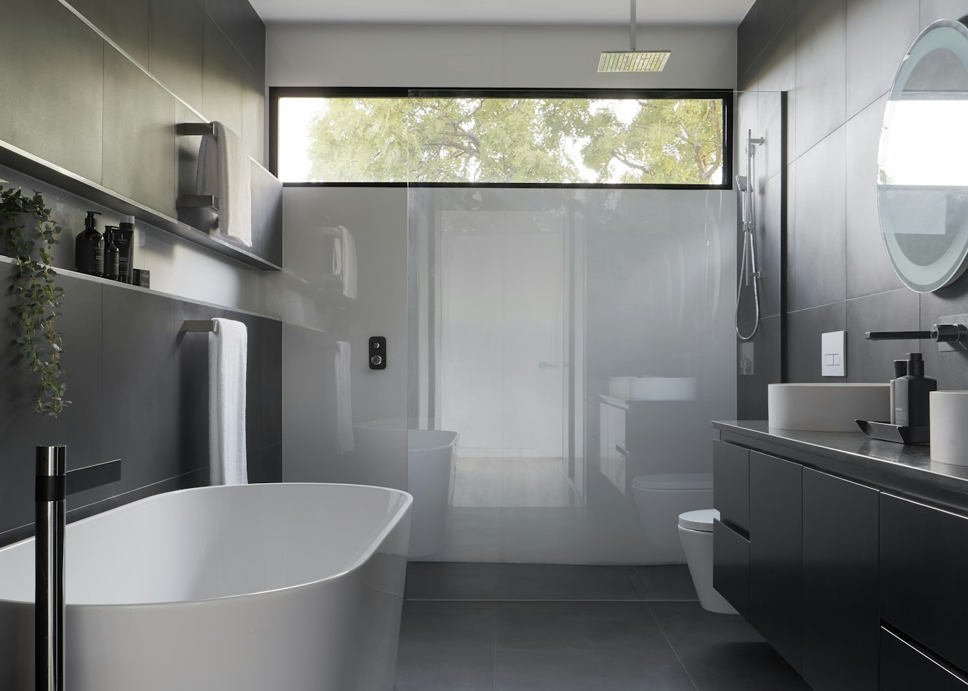 Freestanding bathtub in a grey modern bathroom