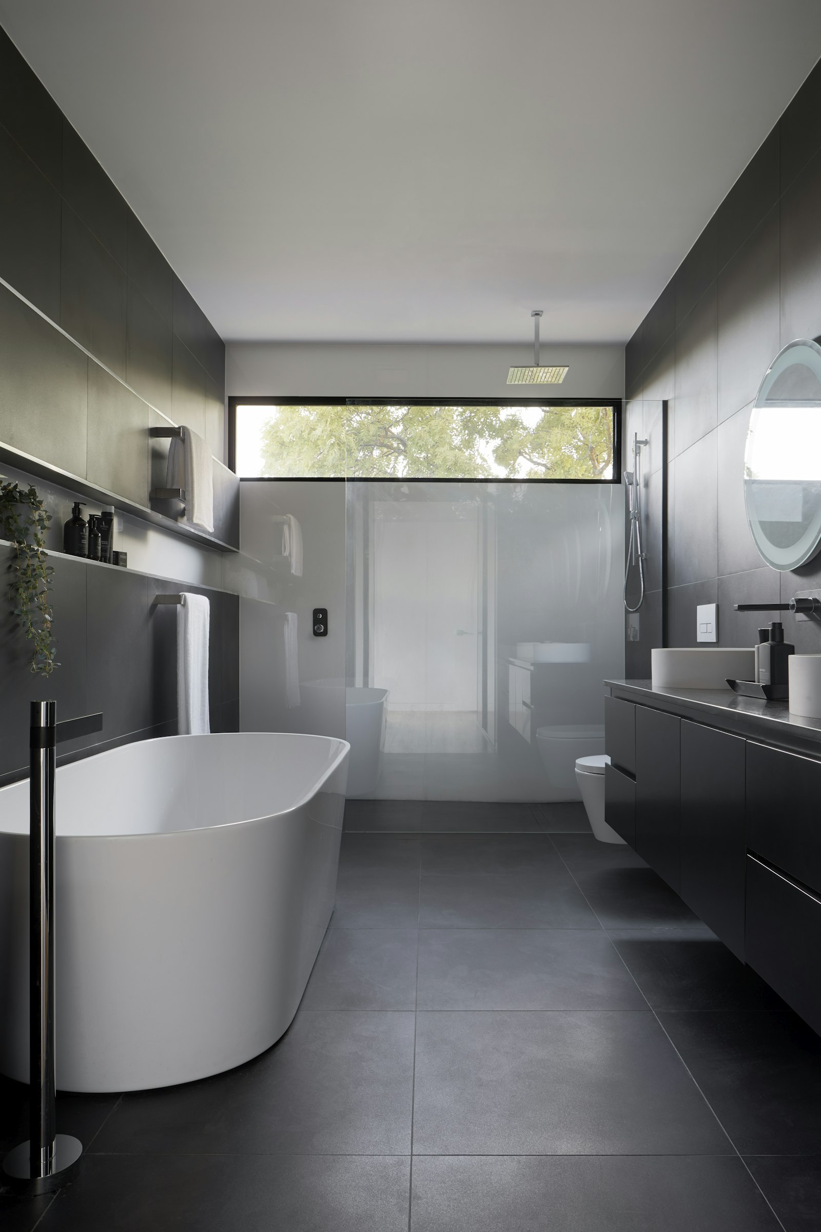 Freestanding bathtub in a grey modern bathroom
