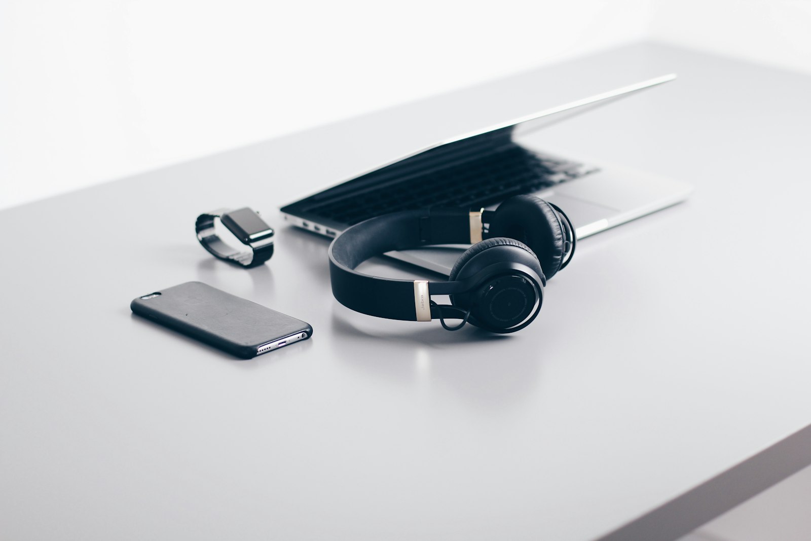 Headphones and phone beside a laptop