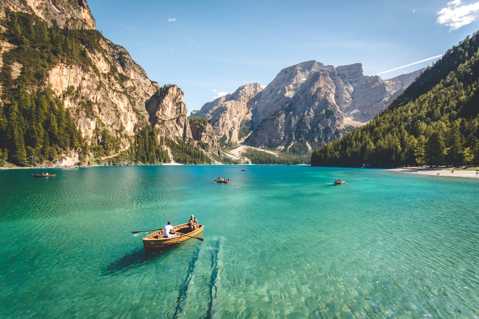 Wooden rowboat on a turquoise alpine lake below rock peaks