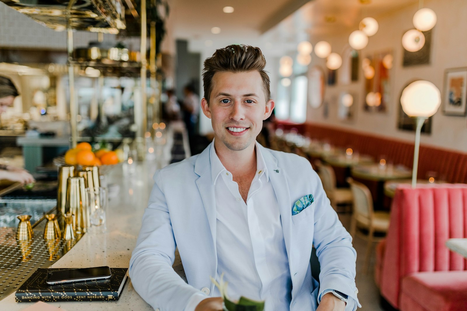 Smiling man in light blazer at restaurant bar
