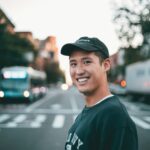 Smiling man in a cap on a city street