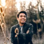 Smiling young man with folded arms outdoors