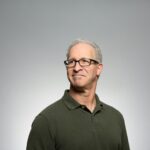 Older man with glasses in olive polo shirt