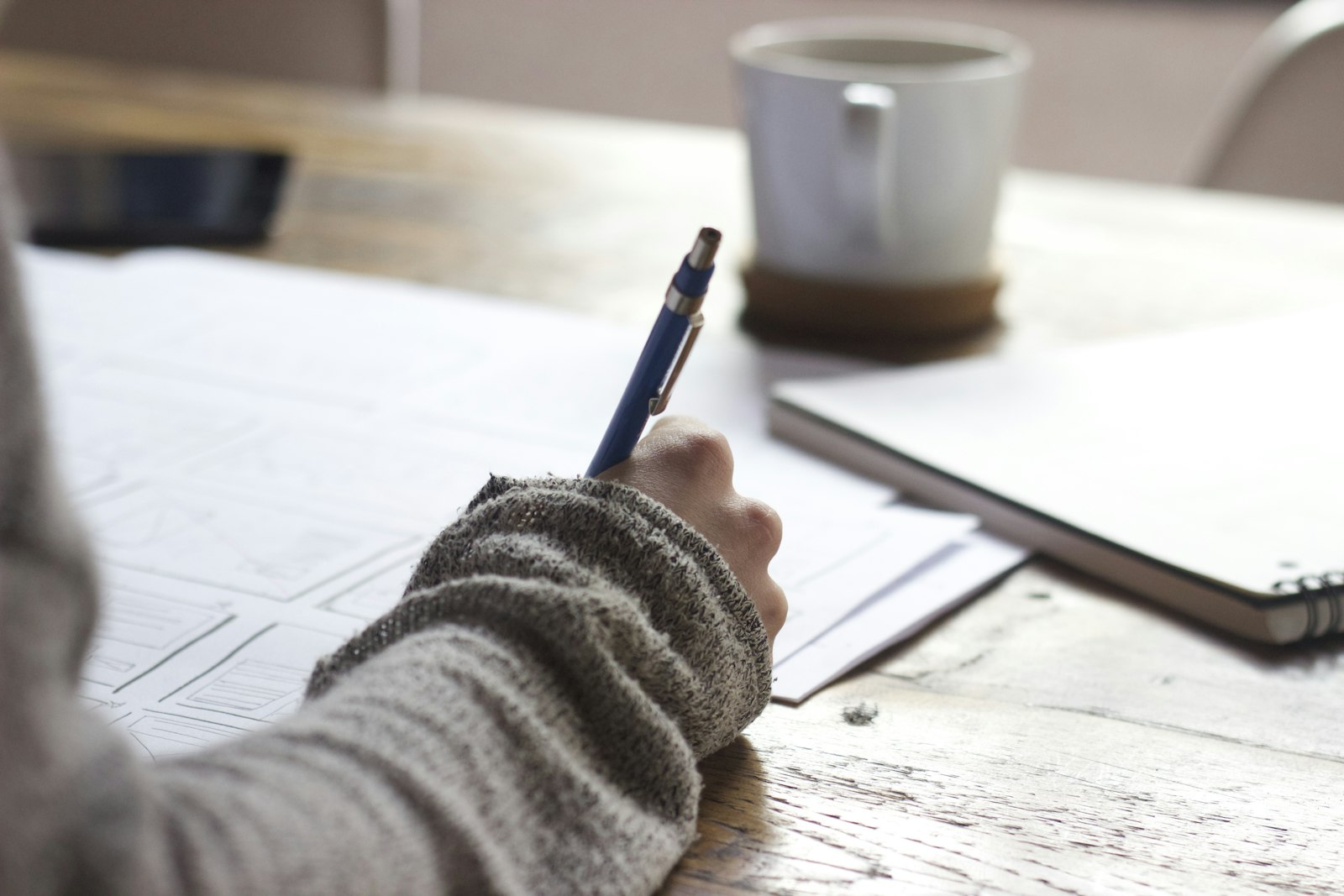 Writing notes at a bright desk