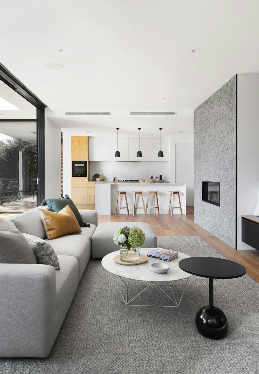 Open-plan living room with grey sofa and wood wall