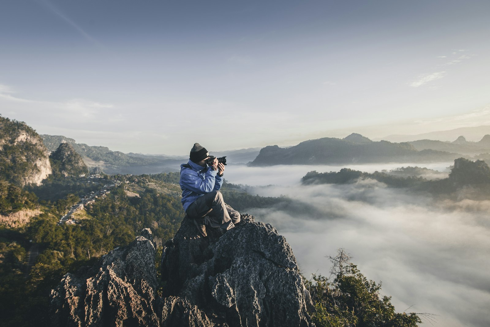 Photographer on a cliff above the fog