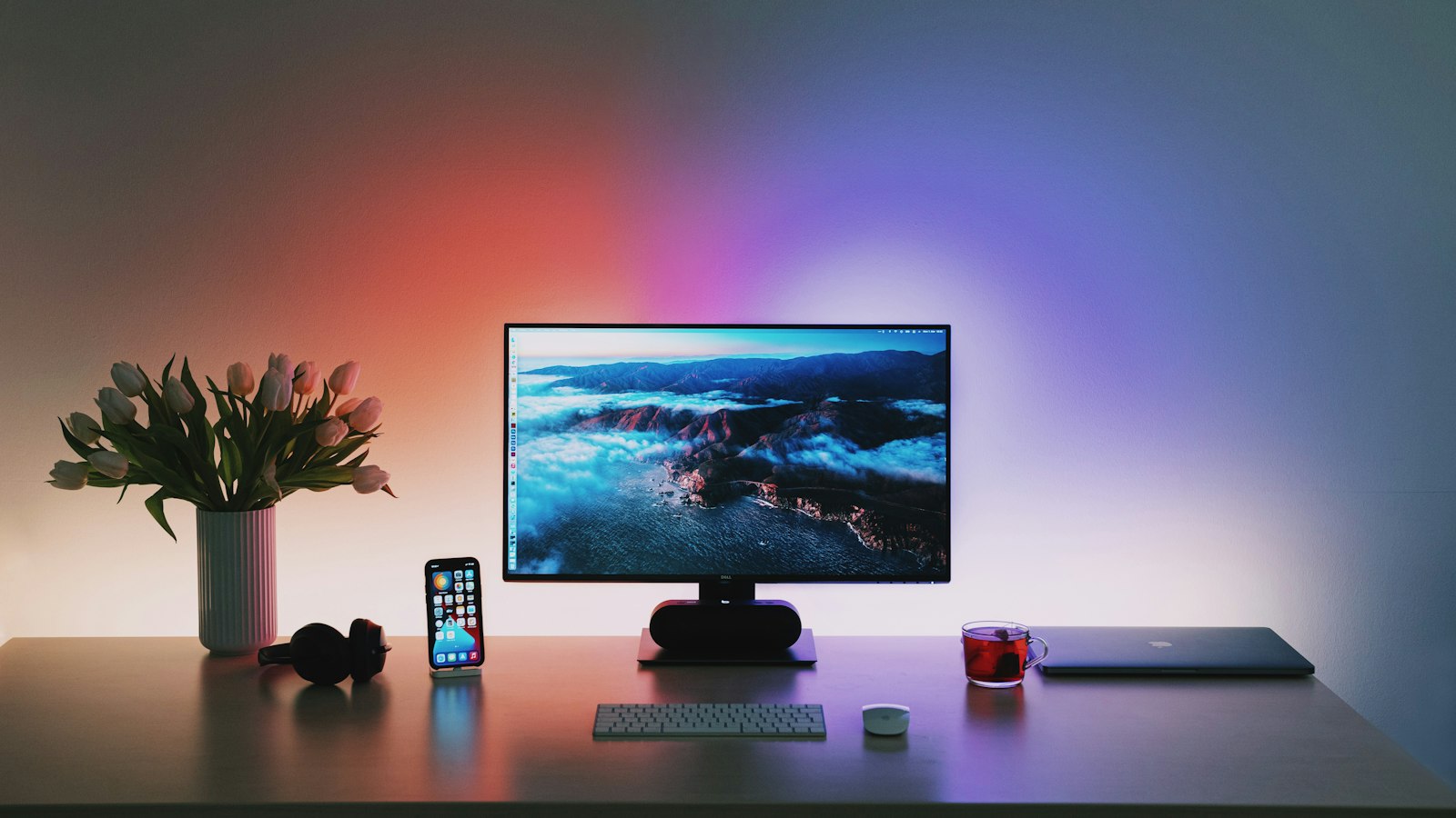 Monitor and tulips on a desk with RGB lighting