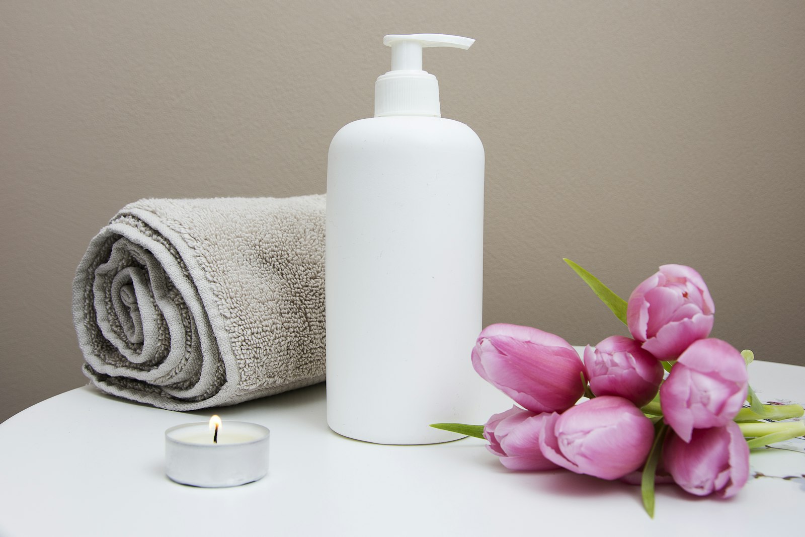 Skincare bottle with fresh tulips