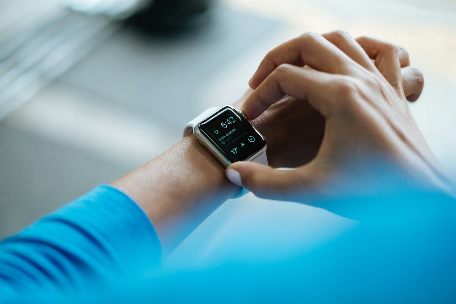 Hands tapping a smartwatch on a wrist