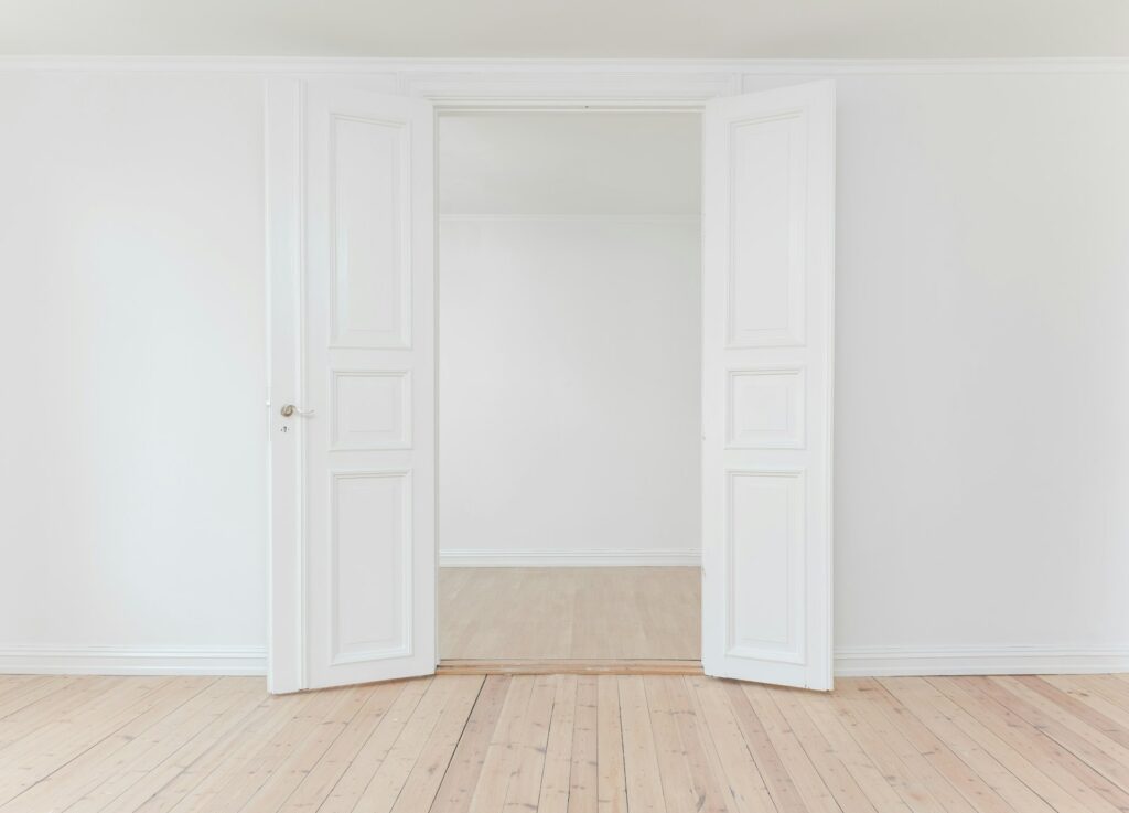 Open white double doors in an empty room