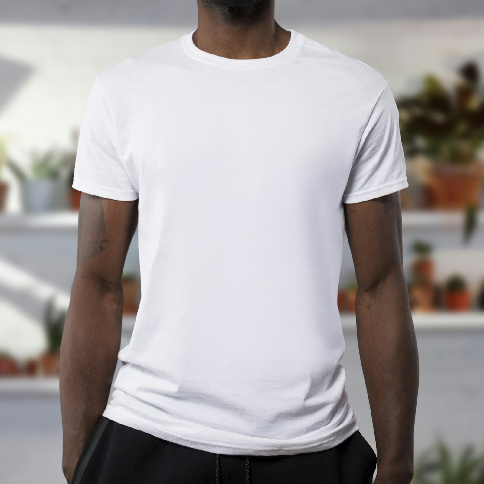Man wearing a plain white crew-neck tee, front view cropped at the chin