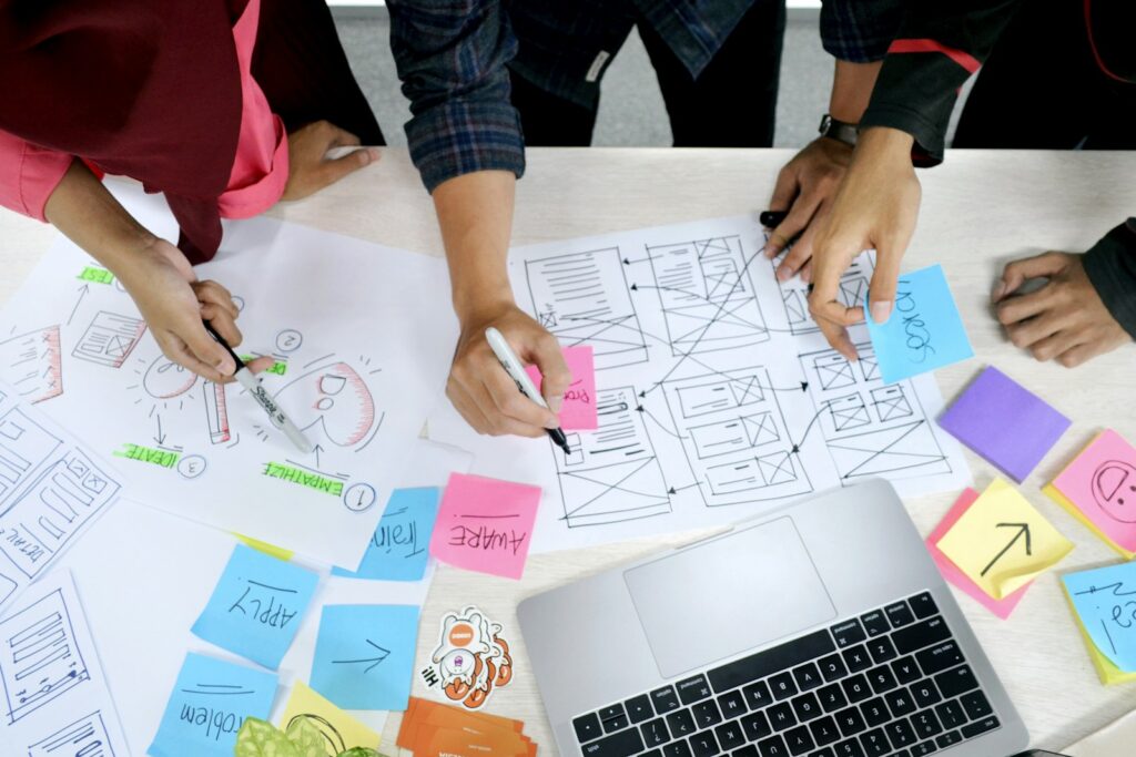 Team sketching wireframes among colourful sticky notes