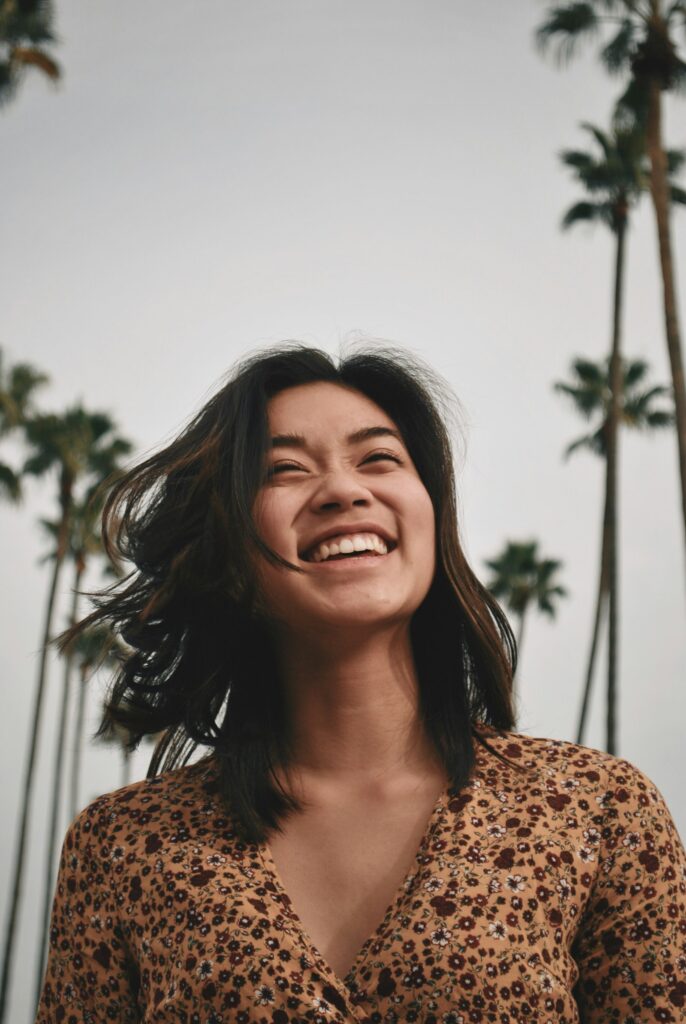 Laughing woman under palm trees
